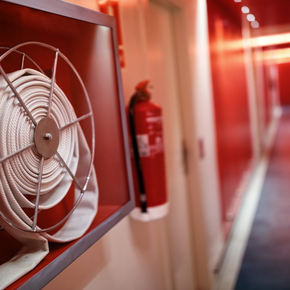 Fire extinguisher and fire hose reel in hotel corridor
